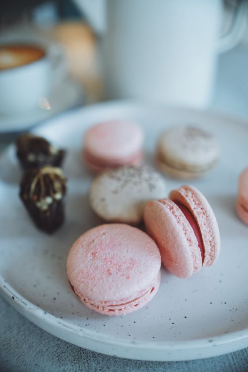 Free Close-up of colorful macarons and chocolates on a ceramic plate, perfect for dessert inspiration. Stock Photo
