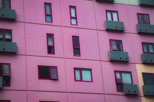 Photo of Building Exterior With Pink Wall and Purple Glass Windows