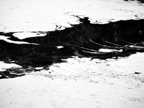 Free Striking black and white abstract photograph of a frozen lake surface with intricate patterns. Stock Photo