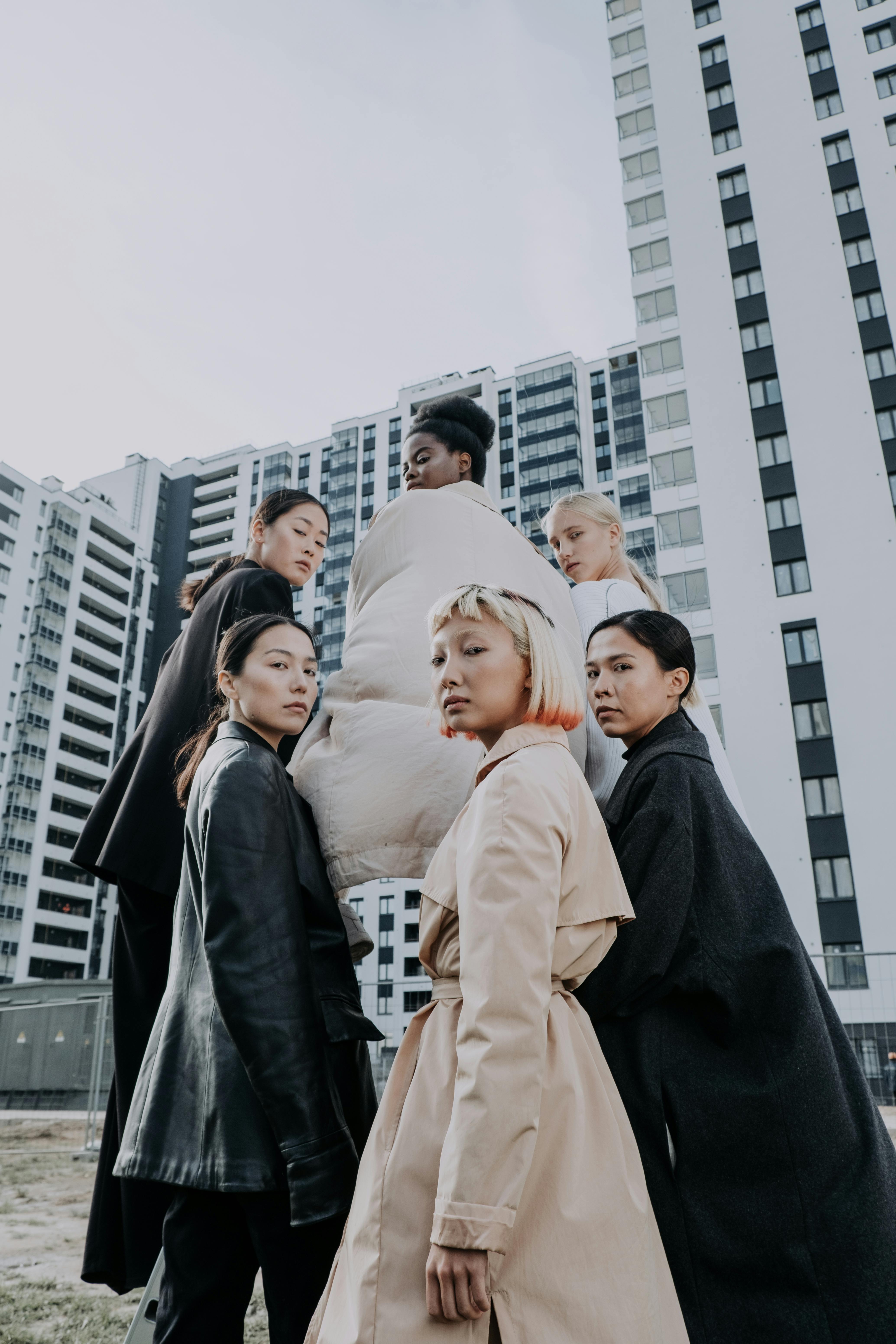 women standing near a building looking over their shoulders