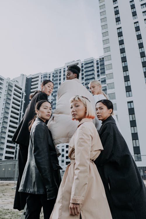 Women Standing Near a Building Looking Over Their Shoulders