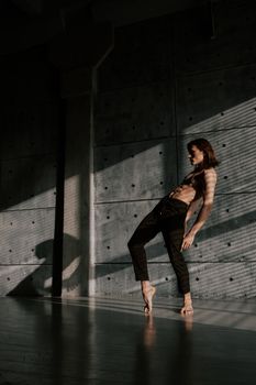 Artistic shot of male dancer with shadow play on concrete wall
