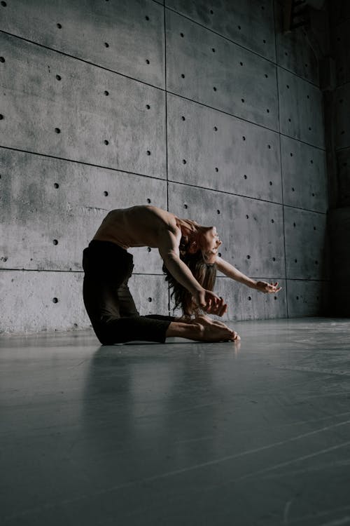 Free Man with Naked Torso Dancing near Concrete Wall Stock Photo