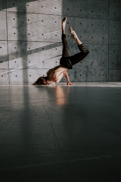 Free Man with Naked Torso Dancing near Concrete Wall Stock Photo