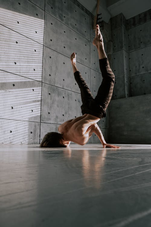 Free Man with Naked Torso Dancing near Concrete Wall Stock Photo