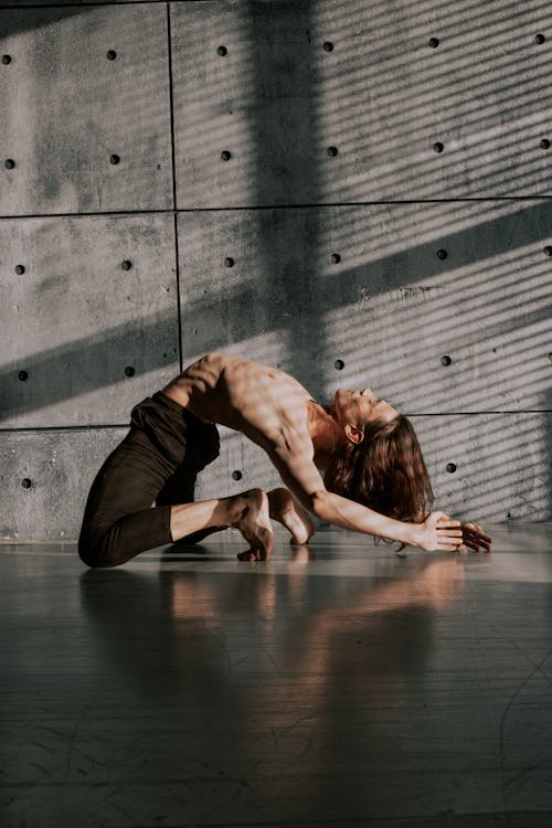 Free Man with Naked Torso Dancing near Concrete Wall Stock Photo