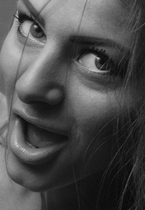 Free Dramatic close-up black and white portrait of a woman with expressive eyes and open mouth. Stock Photo