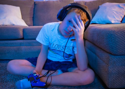 Boy Wearing Headset Sitting on Carpet
