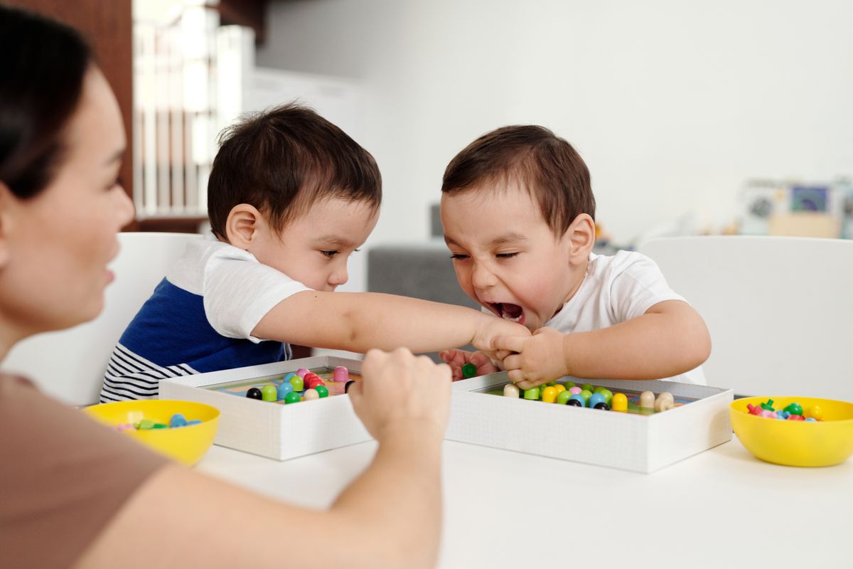 Niños pequeños jugando juntos en la escuela infantil a punto de morder