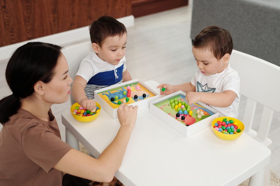 Photo by Jep Gambardella on Pexels A mother and two young children enjoy a playtime session with colorful toys indoors. - Photo by Jep Gambardella on Pexels