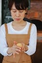 Woman Wearing Brown Apron Kneading a Dough