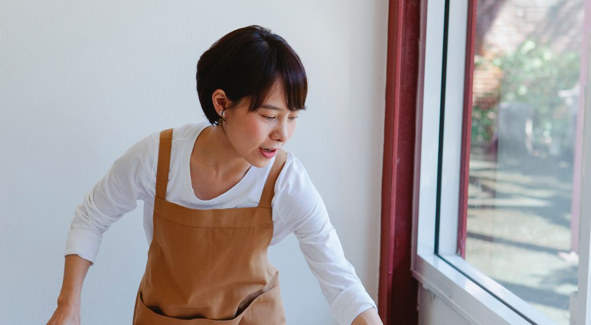 Personne lisant l'étiquette d'entretien d'un tablier de cuisine en coton