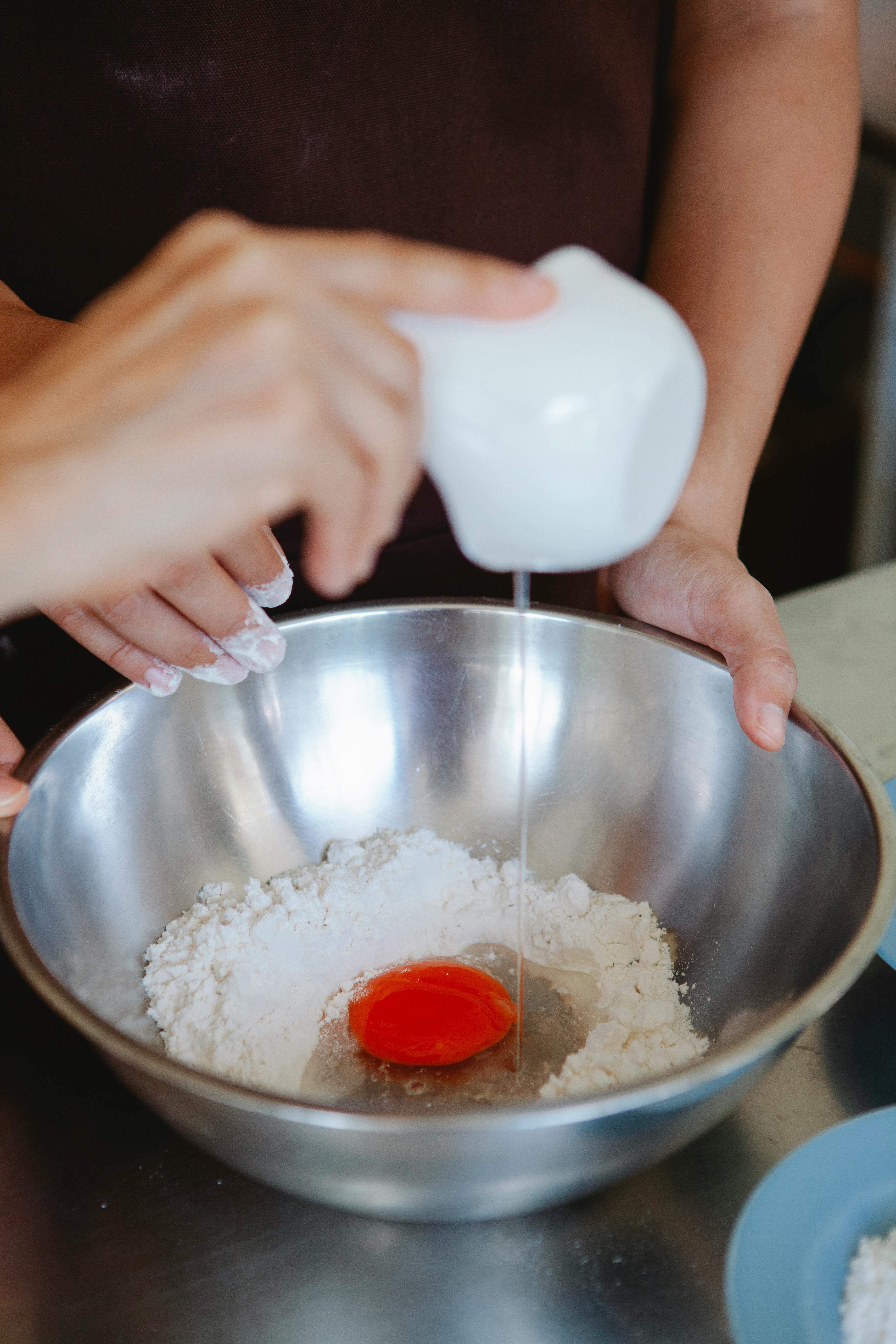 Mixing eggs and flour in bowl hi-res stock photography and images