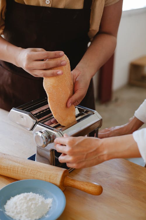 Person Putting Dough in a Pasta Maker