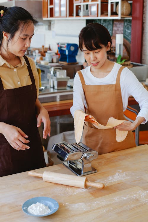 Woman Wearing Brown Apron Holding a Dough