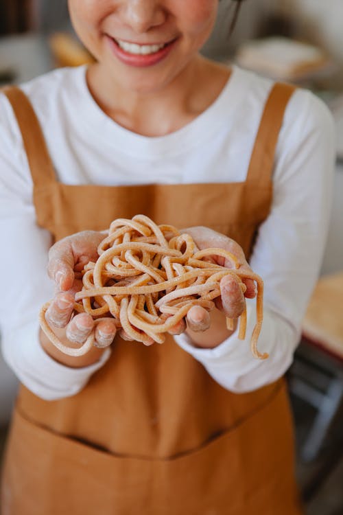 Woman Wearing Apron Holding Noodles