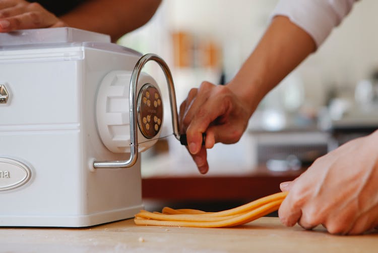 Person Making Pasta On Machine