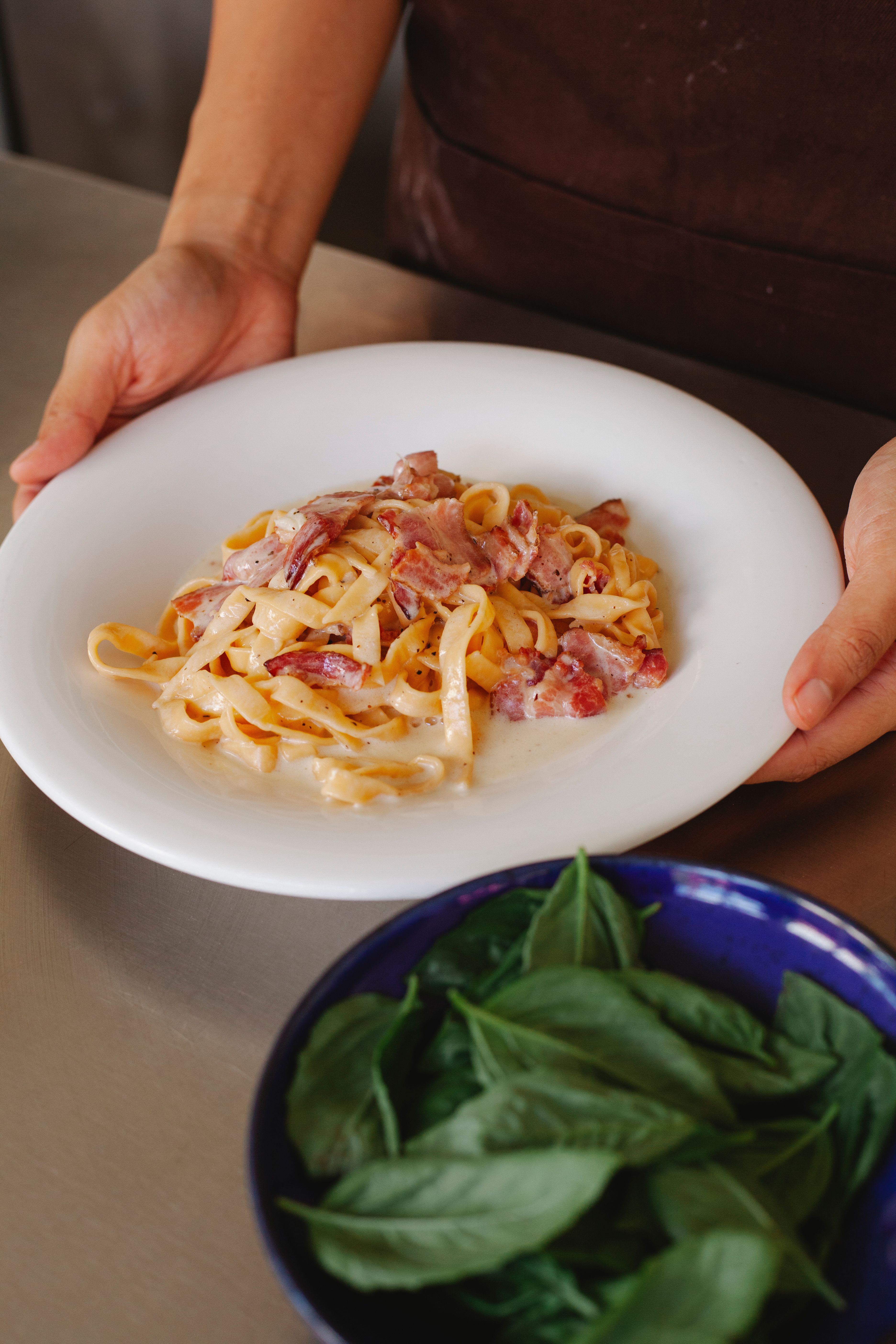 Close-up of a fresh tagliatelle carbonara with basil. Perfect for Italian cuisine lovers.