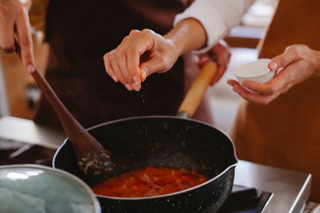 Recipe Developer Career in India: What Food Brands Actually Pay For 1 Close-up of a chef's hands seasoning a dish in a pot while testing a recipe for consistency.