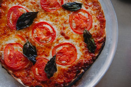 Free Close-up of a Pizza with Tomatoes and Basil  Stock Photo