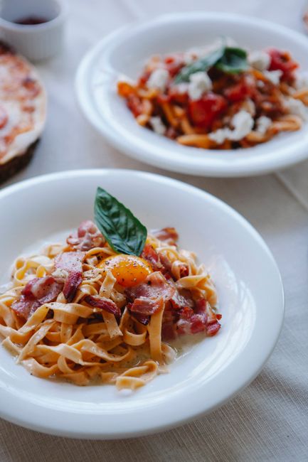 Close-up of tagliatelle pasta with bacon, egg, and basil, perfect for a gourmet meal.