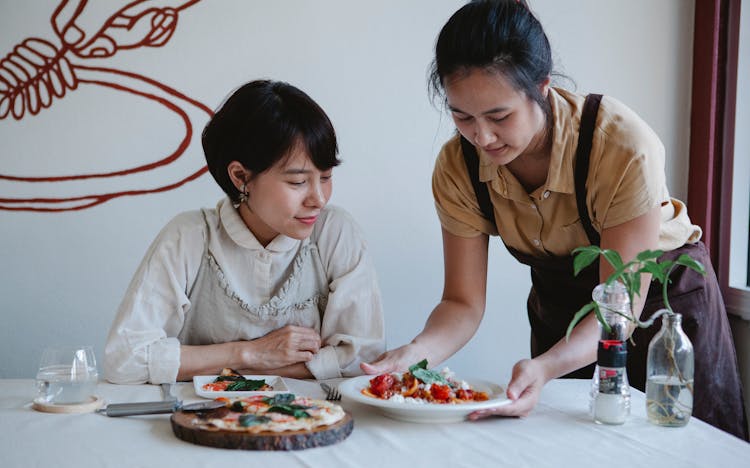 Woman Serving Food On The Table