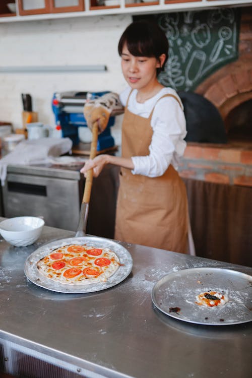 Woman Putting Pizza on Table