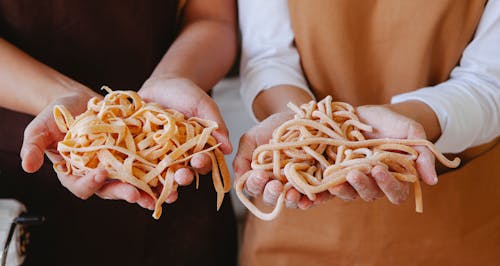 People Holding Kinds of Pasta in Hands