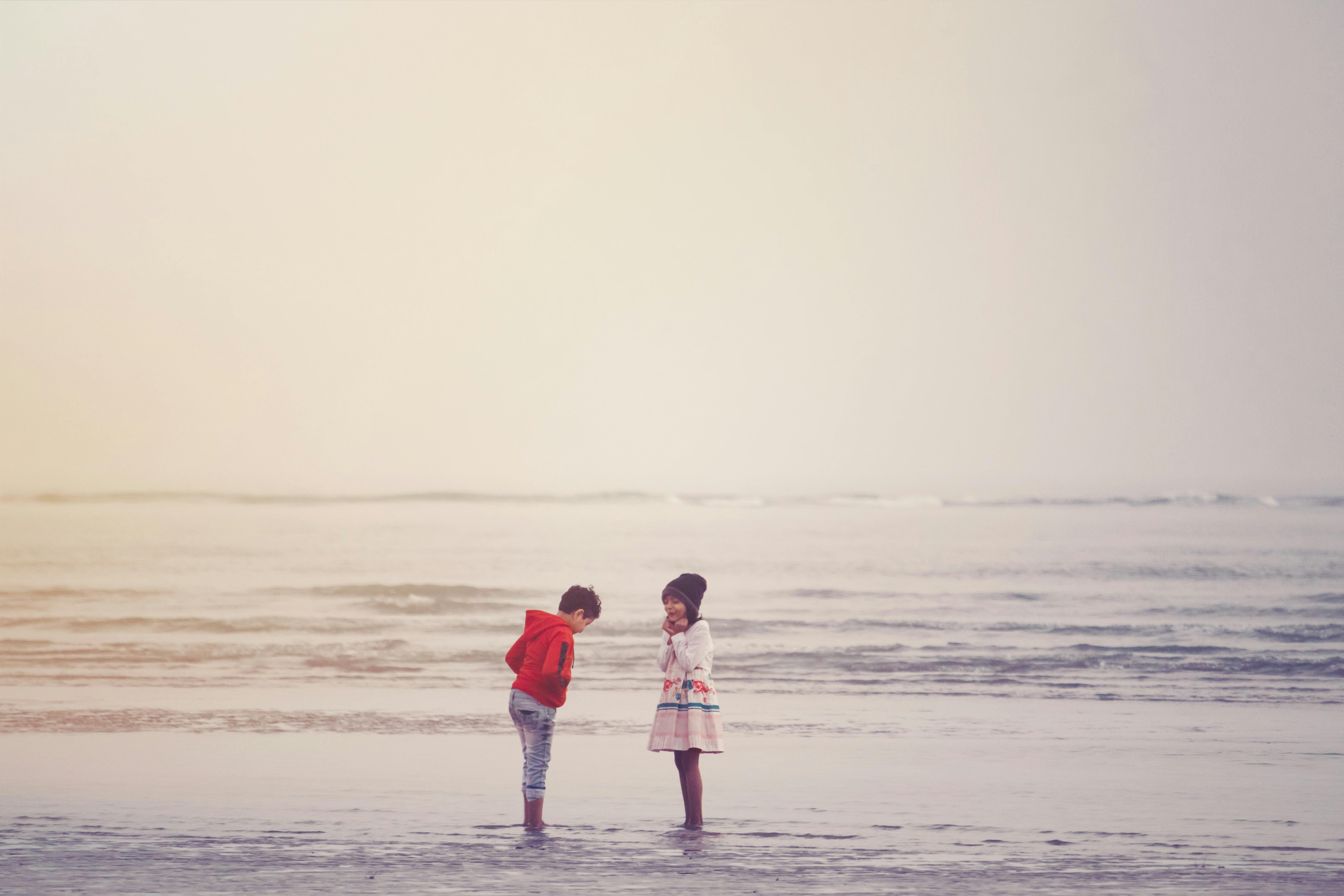 anonymous children resting in sea water at sundown