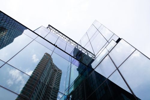 Free Modern skyscraper with glass facade reflecting the Bangkok cityscape. Stock Photo