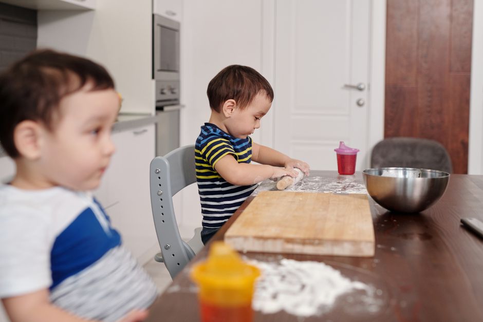Two young boys having fun baking with flour in a modern kitchen setting.