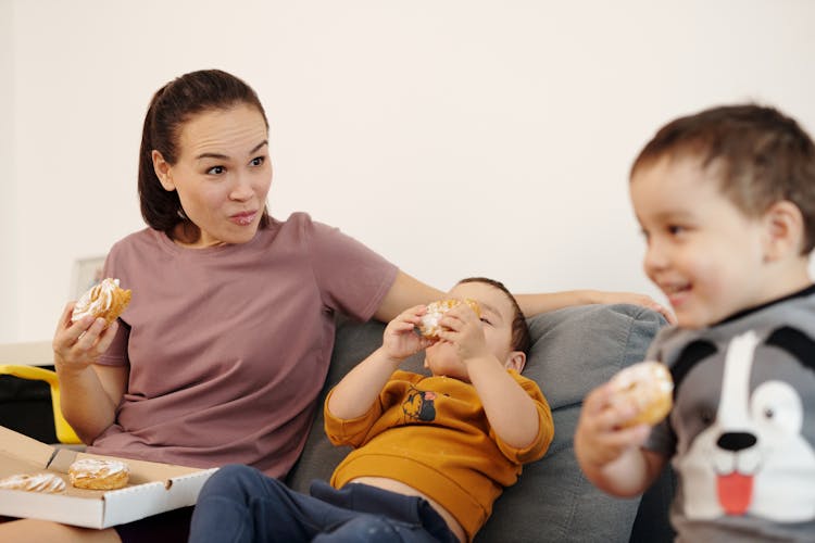 Woman Eating Bread With Children