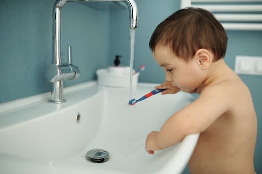 Adorable child brushing teeth at a bathroom sink, learning hygiene routine.