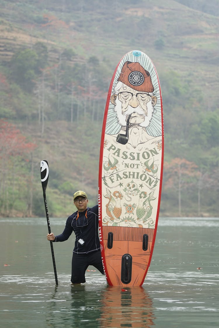 Man Holding A Paddle Board