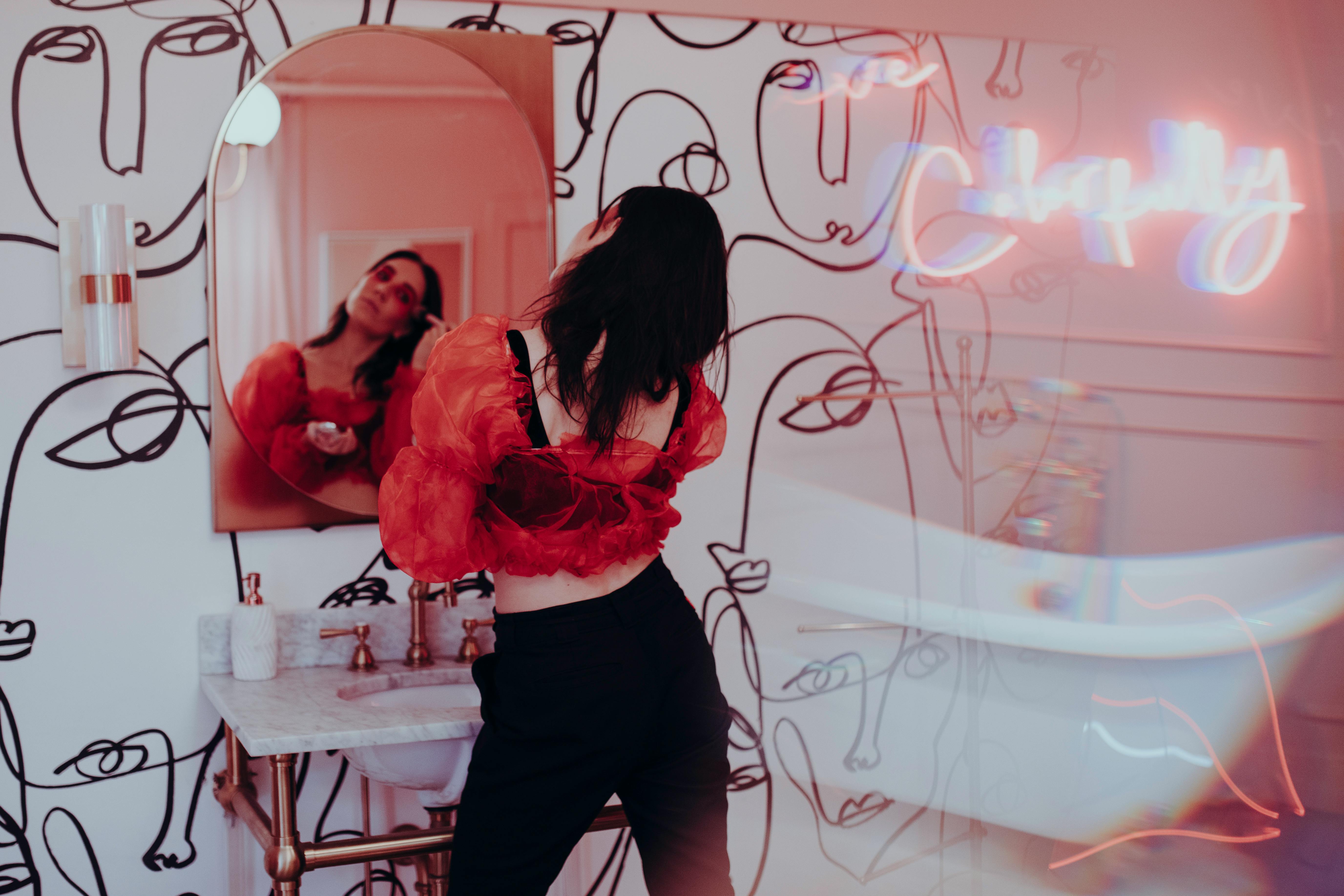 woman in red long sleeve shirt and black pants standing beside woman in black pants