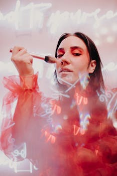 Close-up of a woman applying makeup with artistic neon projections.