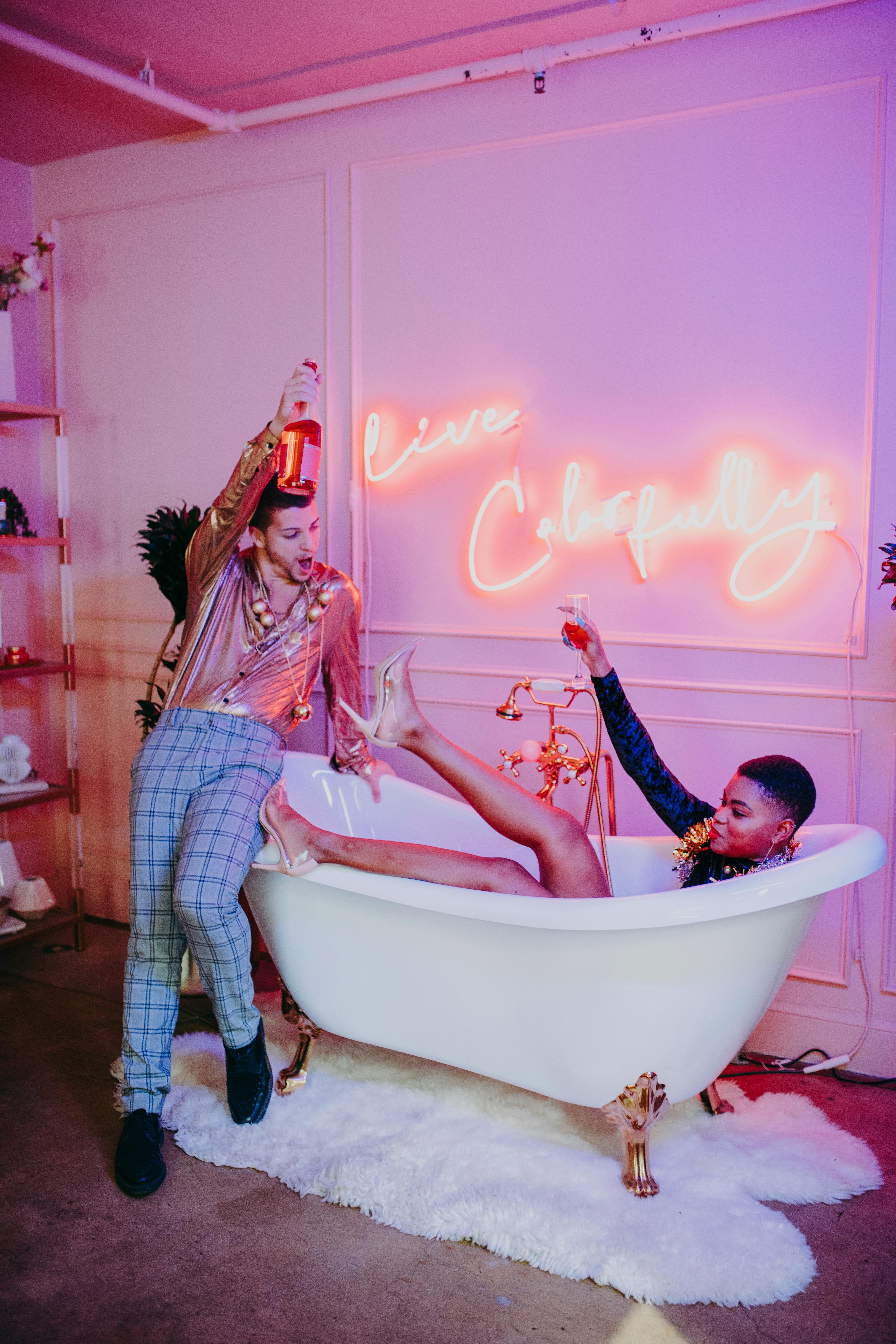 two stylish people hanging out on a bathtub