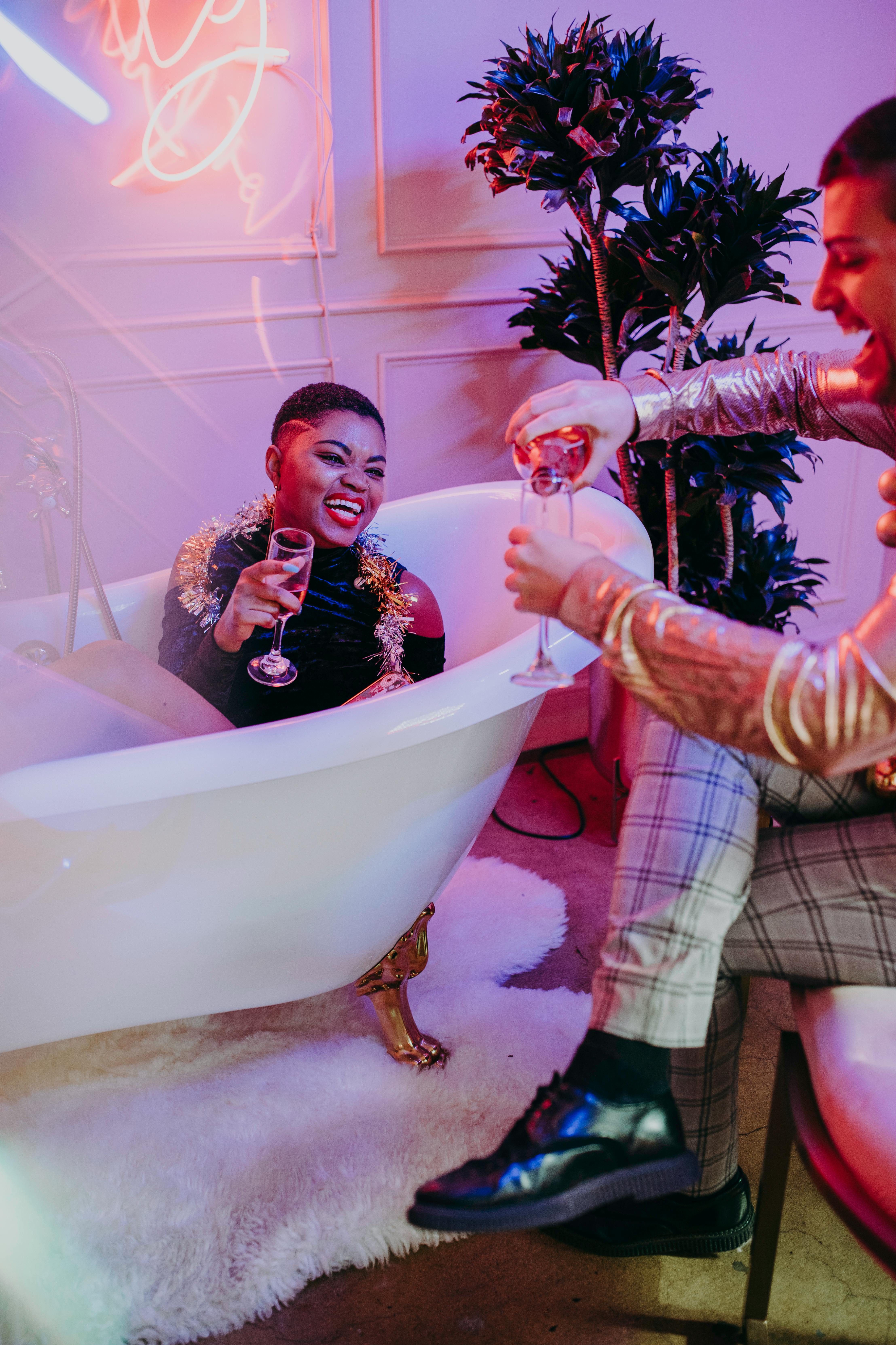 Two friends joyfully celebrating with champagne indoors, capturing a festive and vibrant atmosphere.