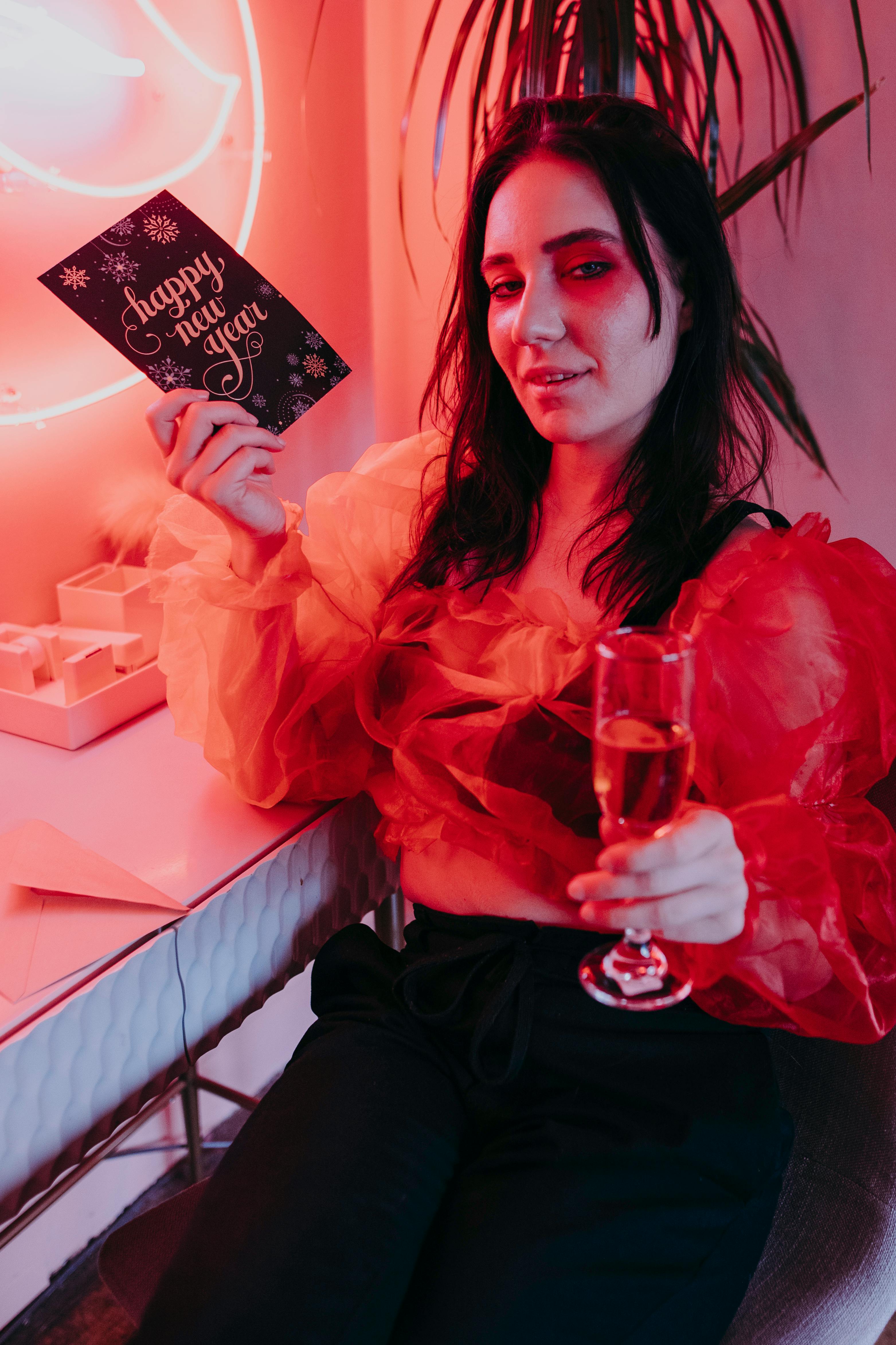 woman holding a greeting card and a glass of wine