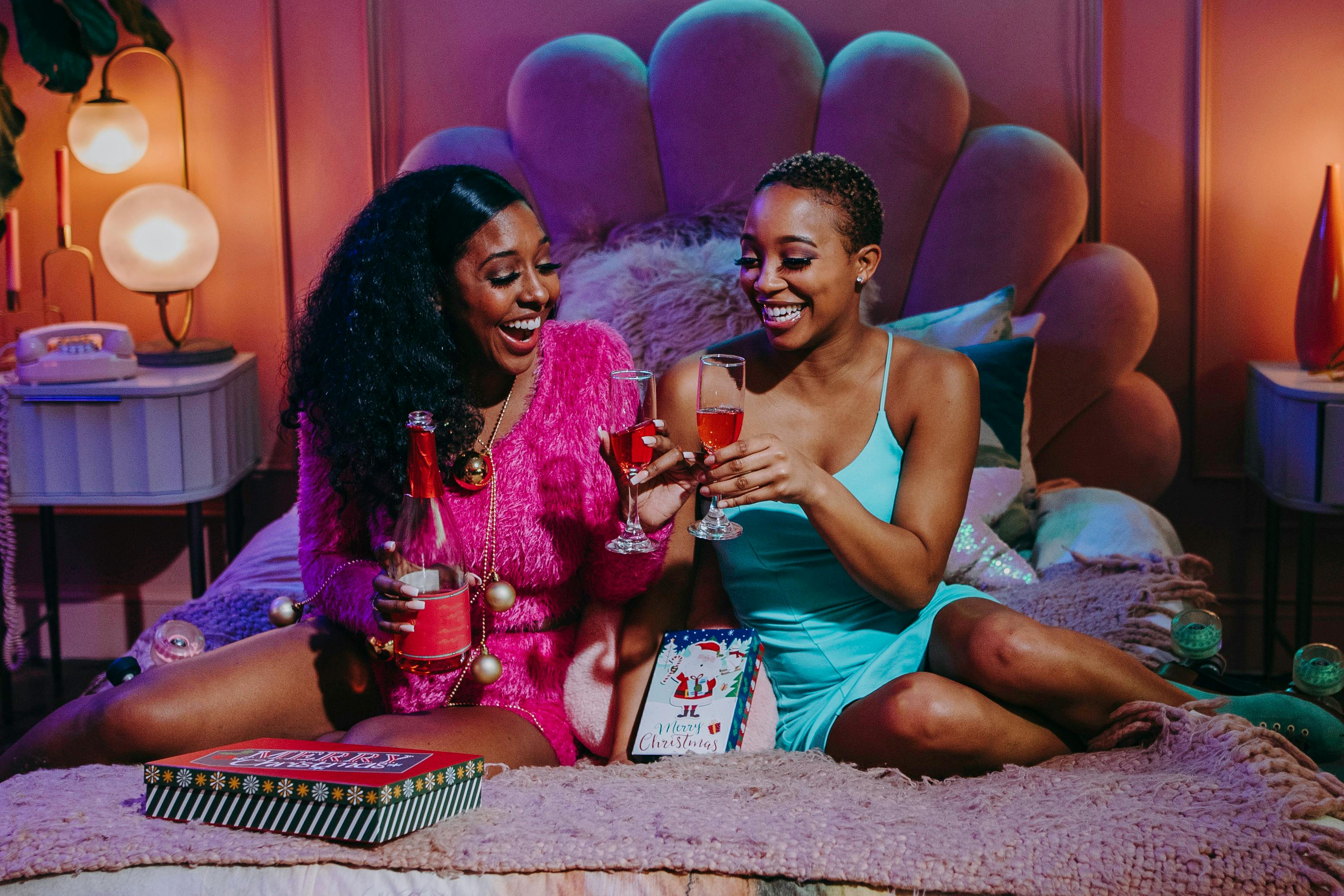 woman in blue tank top sitting beside woman in pink and white tank top