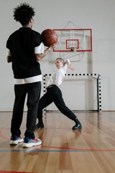 Teenage boys engaged in a dynamic basketball game on an indoor court.