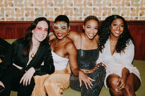 Free A lively group of friends in festive attire enjoying a New Year's celebration indoors. Stock Photo