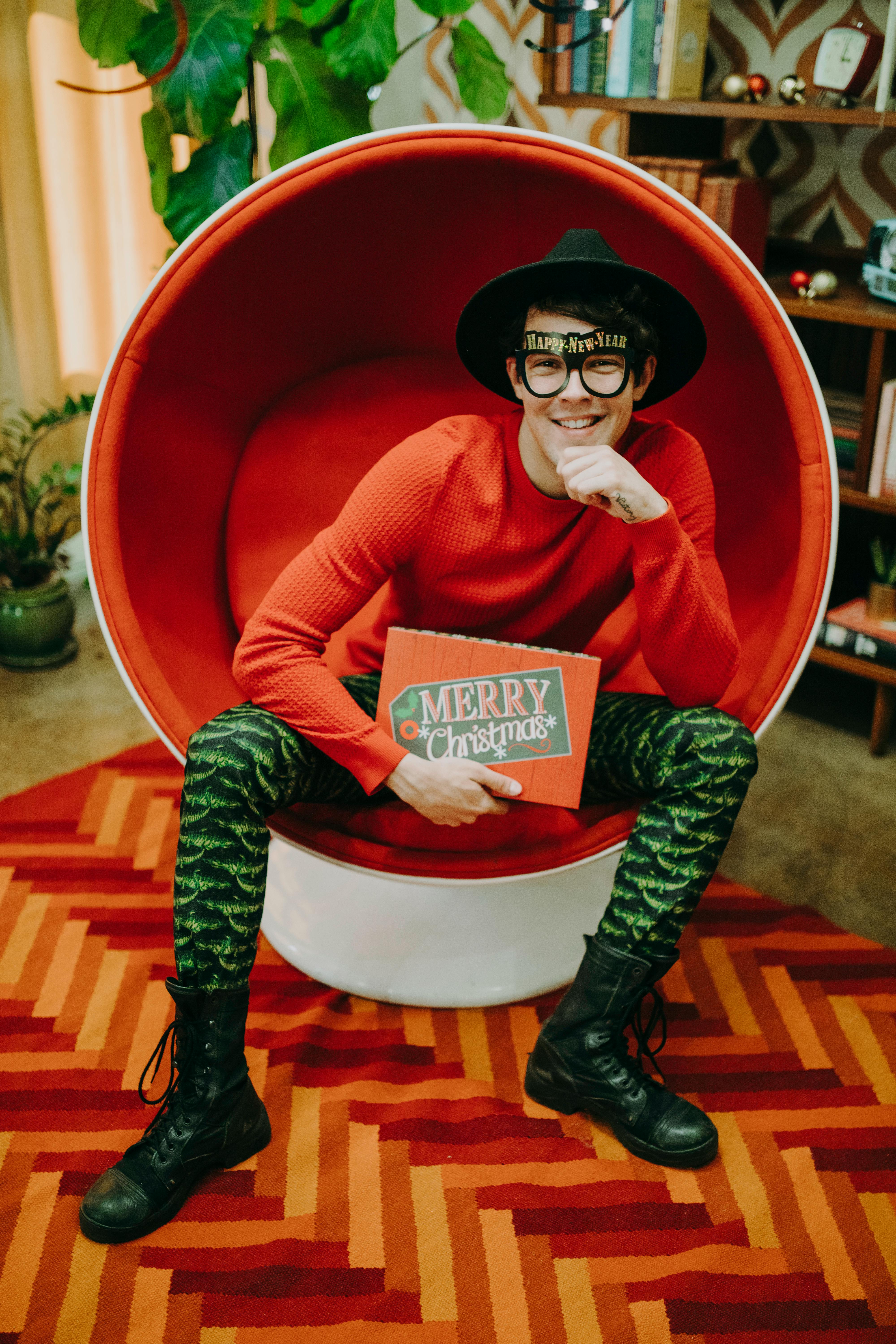 woman in red sweater sitting on red plastic chair