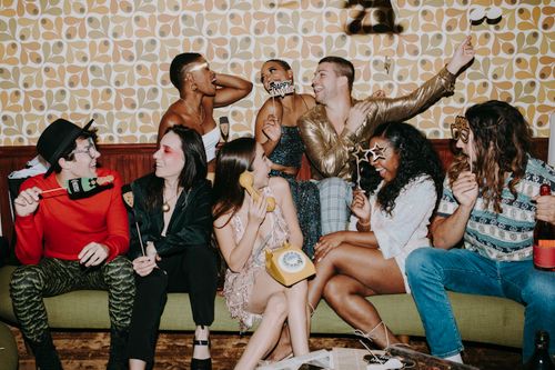 Free Group of friends enjoying a lively New Year's Eve party with laughter and festive decorations. Stock Photo