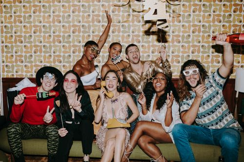 Free Joyful friends celebrating New Year's Eve at a festive indoor party, filled with laughter and fun. Stock Photo