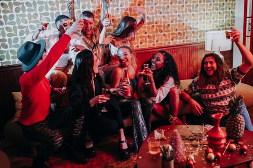 Free Energetic gathering of friends celebrating with drinks indoors. Stock Photo