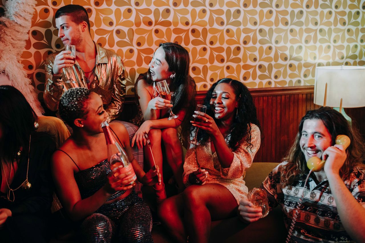 group of diverse young adults enjoying a lively indoor celebration wit