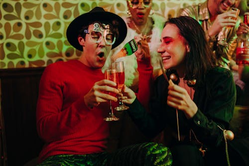 Man and Woman Holding Champagne Glasses at a Party