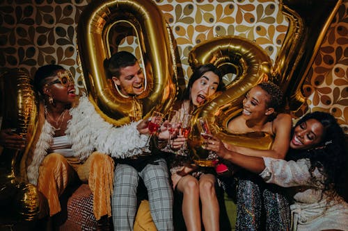 Man and Women Holding Balloons While Having a Toast