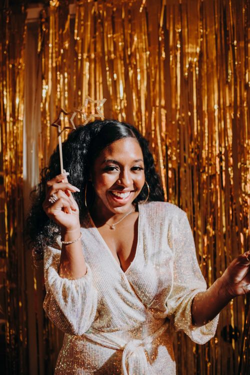 Free Smiling woman in festive attire celebrates indoors with shiny decor. Stock Photo
